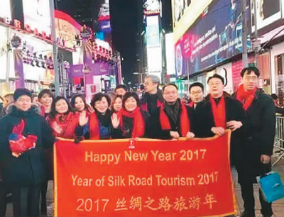 在纽约时报广场新年倒计时运动现场，大众手持“2017丝绸之路旅游年”的条幅庆贺跨年。